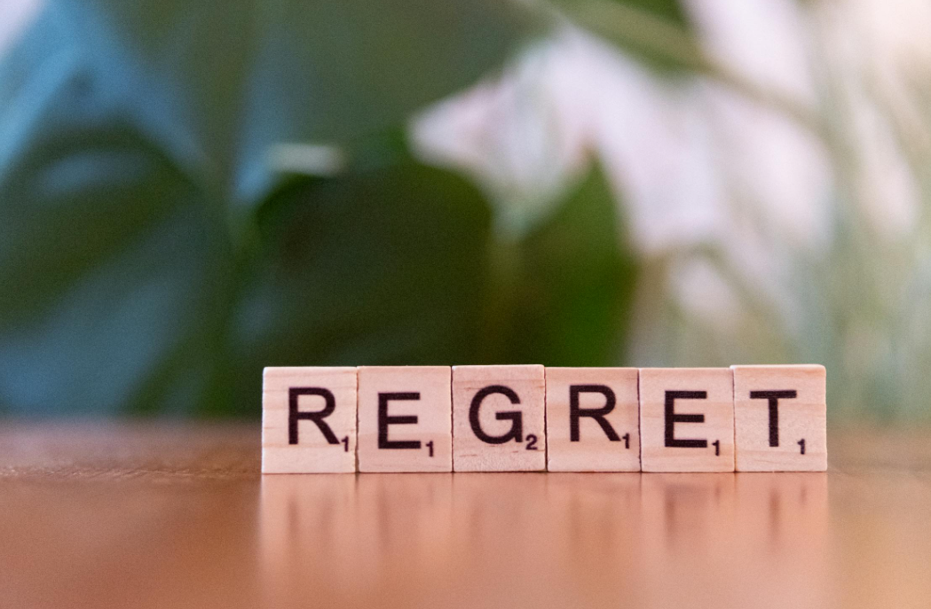 wooden letter tiles spelling 'Regret’