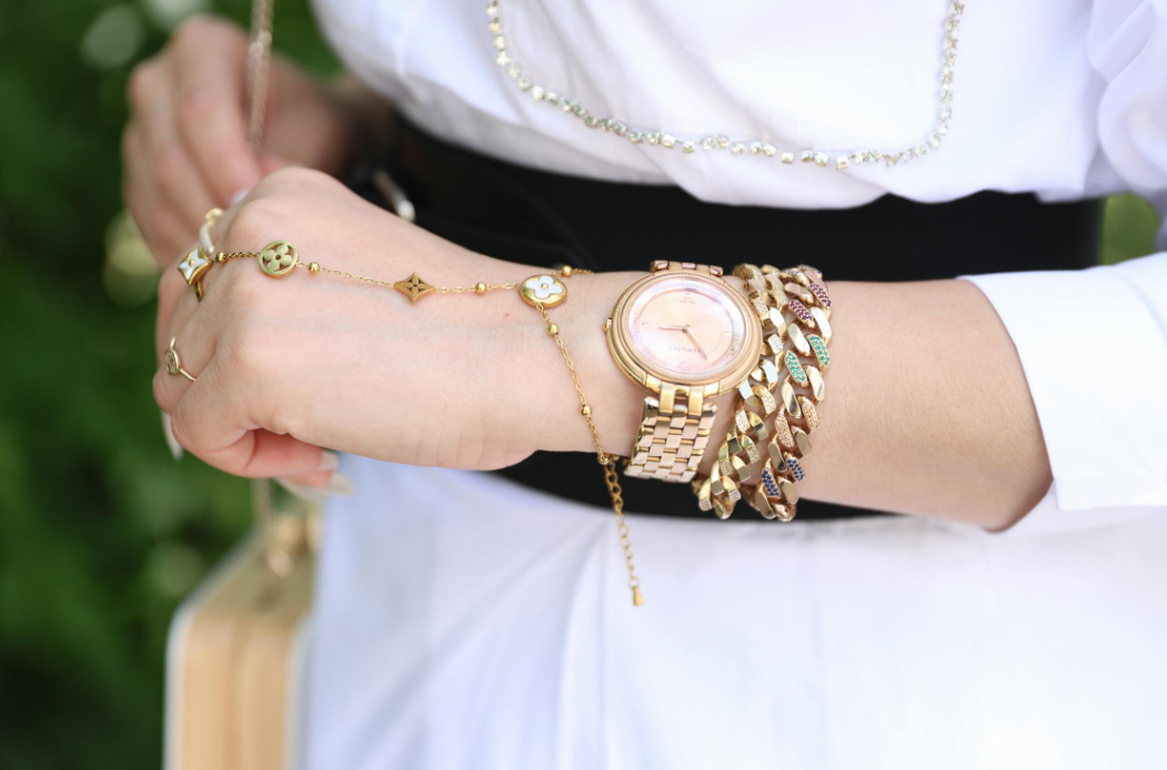 a woman wearing a wristwatch and jewelries