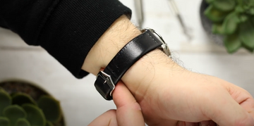 a man checking his watch’s bracelet for tightness